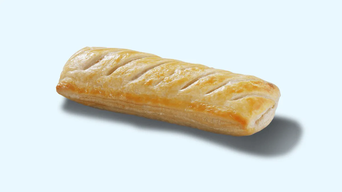 a sausage roll on a plain light blue background