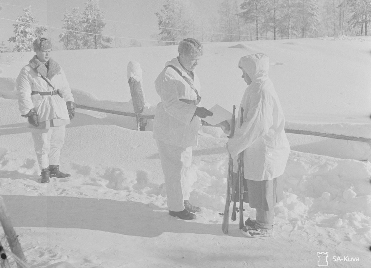 Svenska militära biståndet till Finland under Vinterkriget var omfattande. Förutom de nästan 10.000 frivilliga sände SWE under de 105 krigsdagarna materiel till ett värde av nästan 10 miljarder SEK i dagens värde. På bild mottar Simo Häyhä ett svenskt gevär fr genral Svensson...