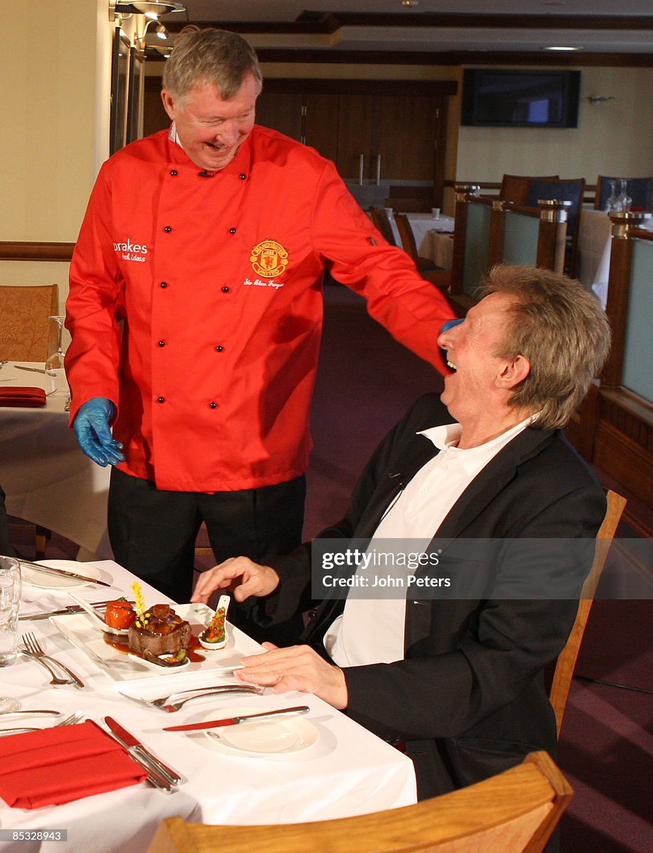 Sir Alex Ferguson of Manchester United takes part in the MUTV cookery programme Red Devils Kitchen, cooking for United legend Denis Law at Old Trafford (2009)