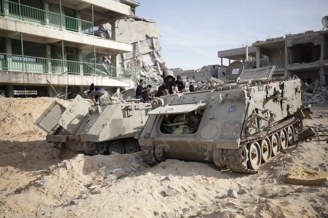 TamaraINassar's tweet photo. No clearer image of Israel's defeat than Palestinians standing atop its destroyed armored vehicles in Gaza. https://t.co/TMWes3jJuY