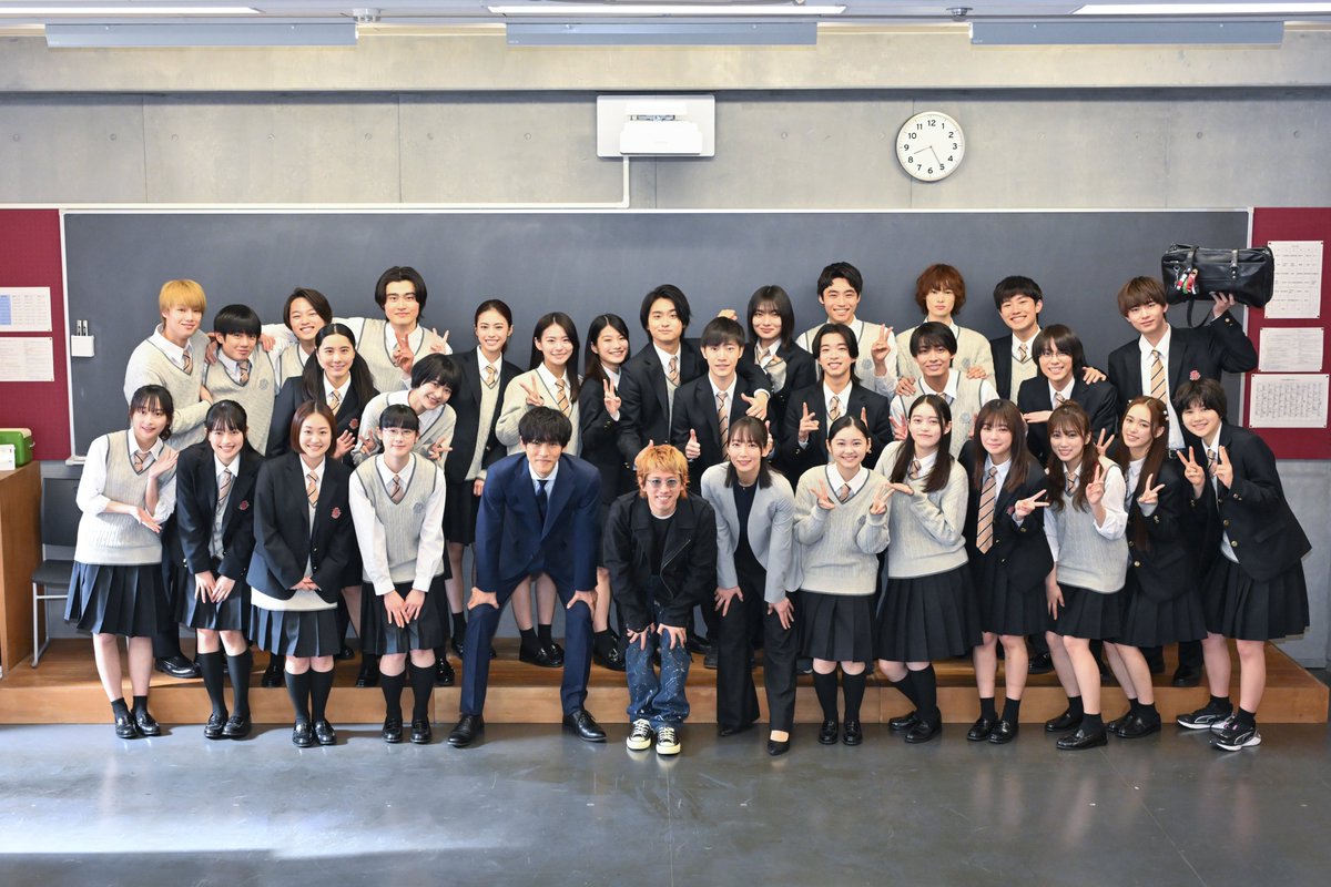 rocqnow's tweet photo. ONE OK ROCKが主題歌を務めるドラマ「御上先生」の撮影現場に、Takaがサプライズ登場した際の写真が公開された。右上で豊田裕大はワンオクのラババンやキーホルダーが付いたスクールバッグをかかげている。これは彼の演じる生徒・宮澤涼が、ワンオク好きという裏設定から制作された小道具。画像は4K。 https://t.co/LaYdKBoYNa