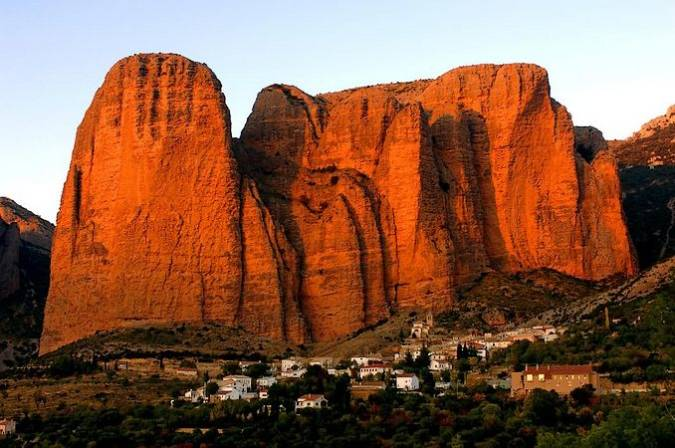 JESUS_M_GN's tweet photo. Los viajes internacionales están muy bien, pero en España tenemos mucho y bueno, por ejemplo "Los Mallos", una extraordinaria formación geológica con moles de paredes verticales de ¡casi 300 m. de altura! de un color rojo-anaranjado encendido, con el pueblo de #Riglos, #Huesca a sus pies, formando el conjunto una postal maravillosa.
En esta formación rocosa destaca El Puro, una fina aguja que se separa del Mallo.

Lugar idóneo para la observación de buitres, alimoches, quebrantahuesos y águilas y "escuchar" el silencio, solo roto por el graznido de las aves.
¡¡NATURALEZA EN VENA!!😀

Paraíso para escaladores, una estela recuerda a los  escaladores han perdido la vida mientras escalaban estas impresionantes moles.