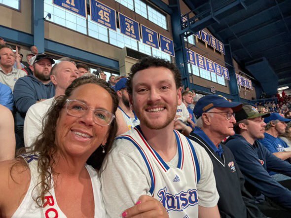 BHanni's tweet photo. Tonight’s #KUCancerFighter hero is Jackson Layton, a 28-year-old from 
Kansas City, KS currently battling Stage 4 colon cancer.

Jackson is a lifelong Jayhawks fan who grew up attending KU Basketball, Football, and Baseball games. He still tunes in faithfully to every game and lists Mario Chalmers as his all-time favorite Jayhawk. His entire family attended KU, but he went to Southern Illinois Edwardsville on a baseball scholarship and played there for four years.

Jackson got his cancer diagnosis just last month and recently began chemotherapy to stop the spread of cancer from his liver and lymph nodes. Though he’s got a long road ahead, he has a determined attitude and positive outlook. He believes he’s been given the platform to make other young people aware of the risk of colon cancer, even at an early age. He encourages early screening so you don’t have to begin your fight at Stage 4 like he’s enduring.

Jackson is resting at home with his wife Hannah tonight, but his mother and two brothers are here representing him.

Jackson, we applaud your courage, determination, and your ambition to provide awareness to others your age. Tonight’s call is for you and we can’t wait to get you back in The Phog soon! 💙❤️