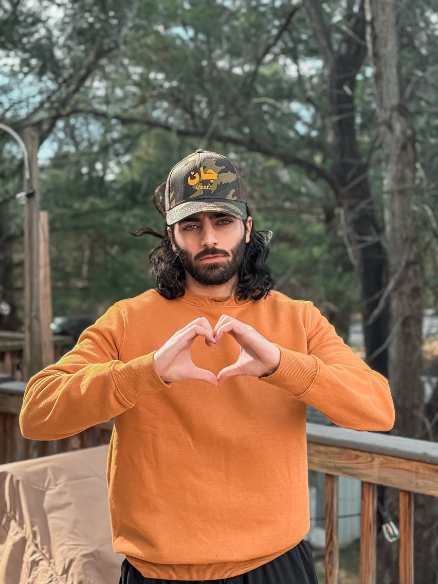 farosty's tweet photo. Jaan (جان) means dear in Urdu/Persian. Particularly from a multicultural perspective — like this patriot from the rivers of Punjab to the Potomac — this hat represents keeping heritage alive while embracing the country you live in, even when it doesn’t always love you back. A love that kills, if you will. Not even the contrasting American rural aesthetic of camouflage can hide this passionate South-Asian term of enDEARmeant. As if to say... Liberty, oh lady – Maarti hai maybe, magar jaan tu hai meri. (You hurt me at times, yet you are the only life I know, so I’ll love you anyway.) Meri Jaan, My Dear 🗽❤️‍🔥