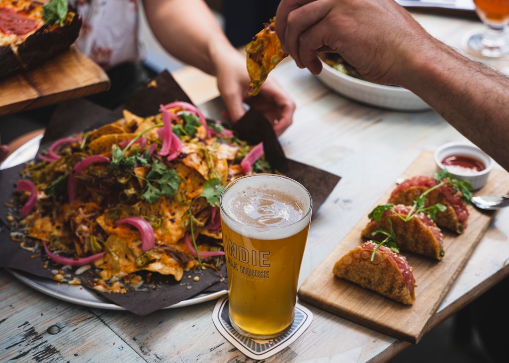 🌮🥳 Who doesn't love a good nacho and beer sesh? Grab your crew, load up on cheesy goodness, and sip on some cold brews because sharing is caring! Cheers to good times and even better flavors! 🍻✨ #NachosAndBeer #CheersIndie