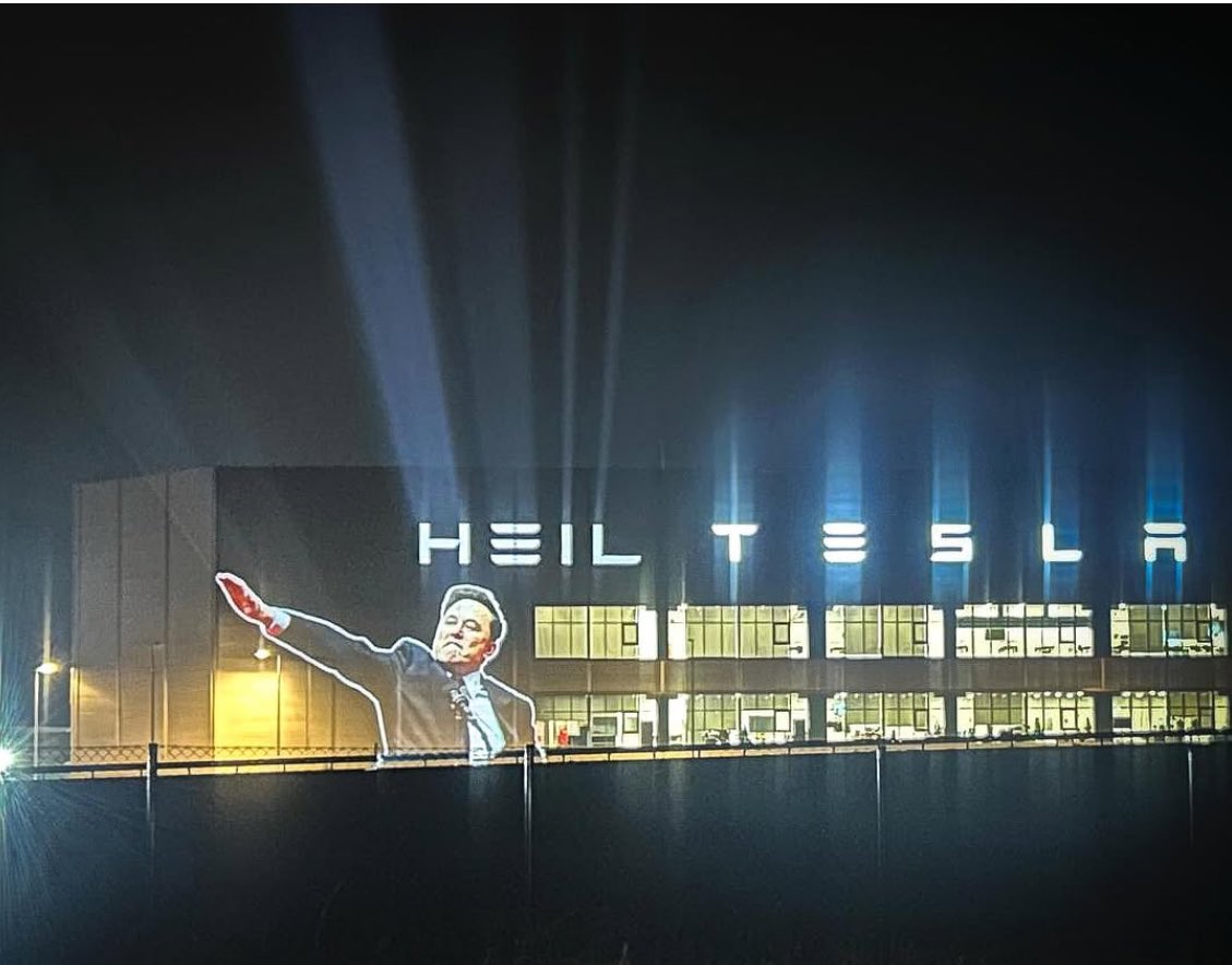 psyche7777's tweet photo. ‘Heil Tesla’: Elon Musk’s salute projected onto carmaker’s factory in Germany #ElonMusk #ElonIsANazi https://t.co/X5X72DS1Xu