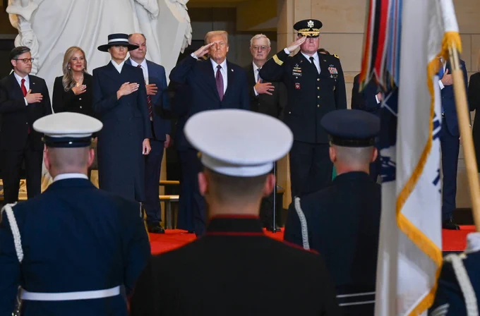 President Trump solutes various uniformed servicemembers alongside First Lady Melania Trump. 