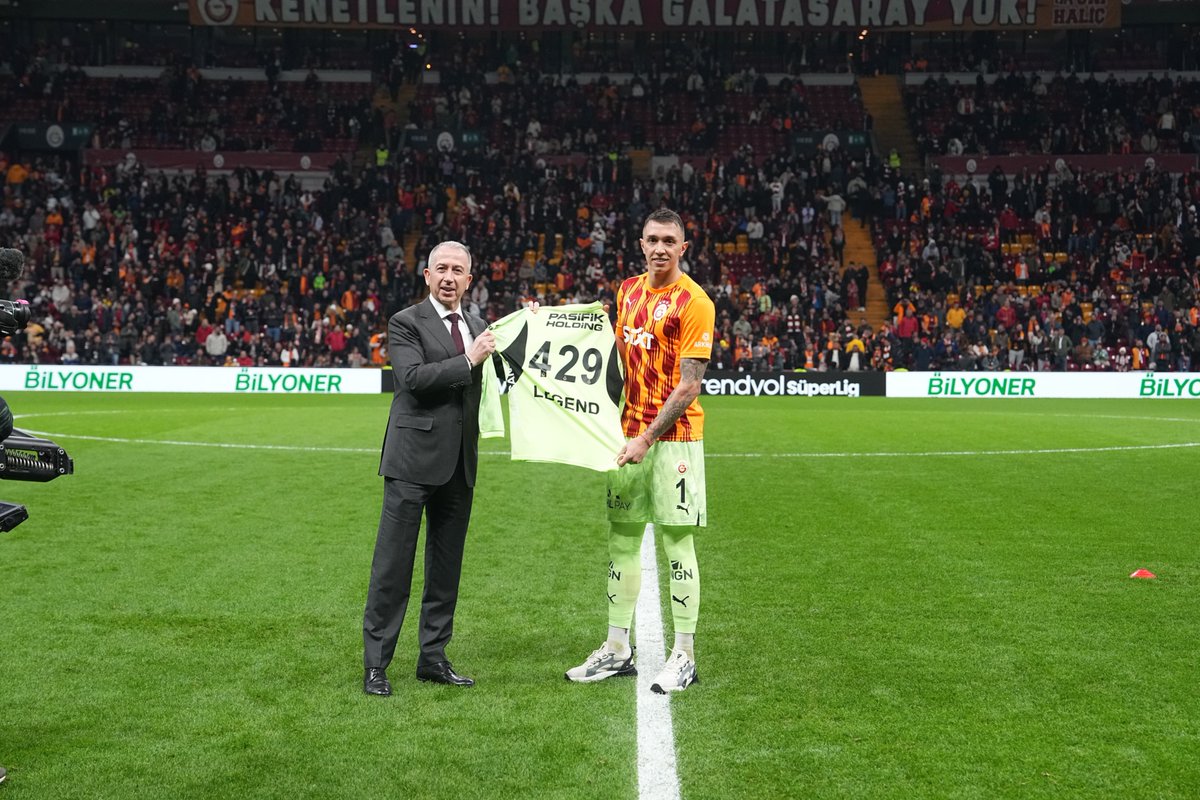 GalatasaraySK's tweet photo. Şanlı formamızla ligde 429 karşılaşmayı geride bırakarak, lig tarihinde Galatasaray ile en çok maça çıkacak isim olan kaptanımız Fernando Muslera’ya, Galatasaray Spor Kulübü 2. Başkanı Metin Öztürk tarafından plaket ve kendisine özel hazırlanan forma hediye edildi. 💛❤️ https://t.co/14YbRZBWW6