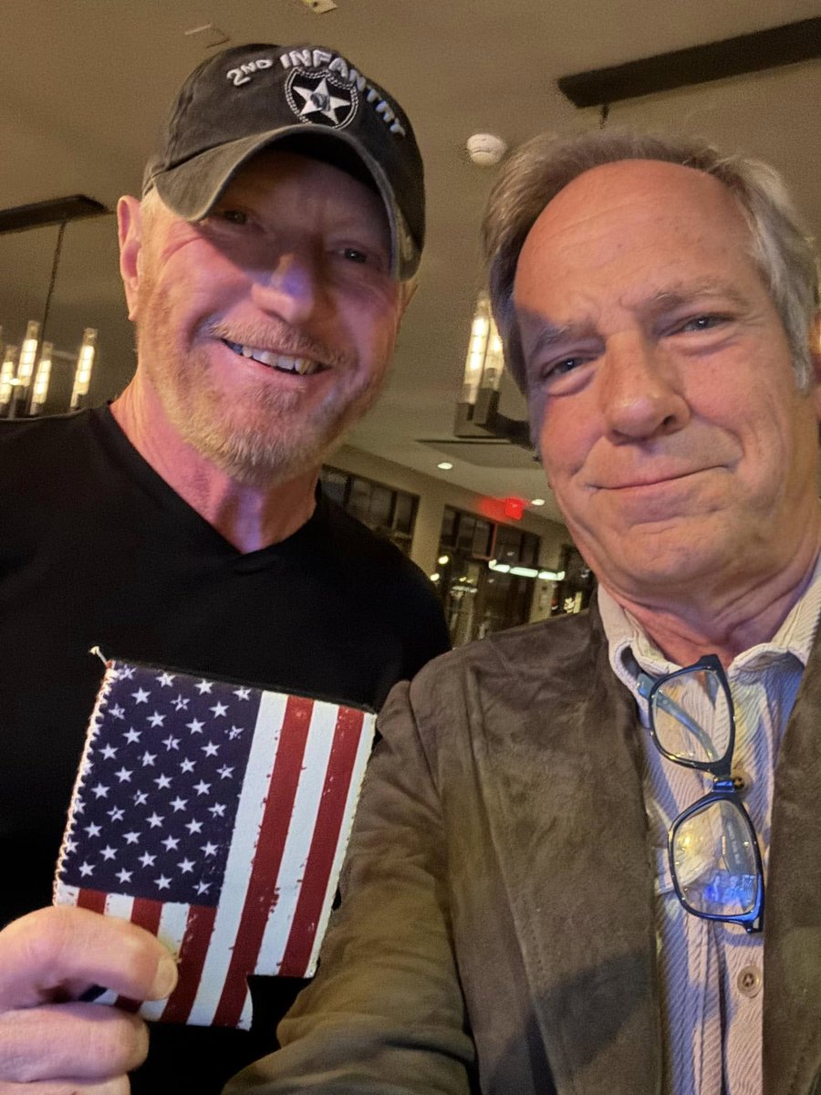 mikeroweworks's tweet photo. I was at the Lincoln Steakhouse last night, sipping a cocktail with a handful of patrons who had decided to have dinner at the bar, when I noticed an attractive woman a few stools down, sitting alongside a grizzled soldier. Actually, what I noticed first was a platter of macaroni and cheese, which the attractive woman appeared to be in no hurry to eat. I had skipped breakfast, the flight to Phoenix was in the middle of the day, and there had been no time for lunch after I arrived. So, there I was at 7:pm, coveting a pretty girl’s mac and cheese in one of Arizona’s great watering holes, when the grizzled soldier next to her stood up and walked toward me.
 
I glanced at his cap and said, “Looks like that lid’s seen some action.”
 
“You know it,” he said.
 
“Army?” I asked.
 
“Marine,” he said.
 
“Really? I thought the 2nd Infantry was Army?”
 
“It is. But we work together every now and then.”
 
“Well, thanks for your service,” I said. “And pardon me for staring, but the mac and cheese caught my eye.”
 
The Marine turned to his date and said, “Nicole, you gonna eat all that? This fella’s hungry.” 
 
Nicole slid her leftovers down the bar, which I appreciated. Then, the Marine introduced himself.
 
“I’m Mark Day,” he said. “And I’d like you to have this.”
 
Mark handed me a beer koozie in the shape of an American flag.
 
“I hand a few of these out every day to my brothers and sisters who were over there with me. It’s a way to remember those people who didn’t make it back.”
 
“Well thanks,” I said. “But I can’t accept this. I didn’t serve, and I was never over there.”
 
“Oh, you were there,” he said. “Used to watch your show all the time. We all appreciate what you do for the military.”
 
Hard to know what to say in a moment like that, especially with a mouth full of his girlfriend’s noodles, so I just said thanks, and promised to put the koozie to good use. 
 
Over the next minute or so, I learned that Mark Day had come from a long line of Marines and seen some difficult things while in uniform. I also learned that he had come to view his own service as the great privilege of his life.
 
“I love this country,” he said. “I love it so much. Not a day goes by that I don’t think about the ones who didn’t make it home. Handing out these koozies is a way to keep them in my thoughts.”
 
“I understand,” I said. “At least, I think I do.”
 
“Well then maybe you’d like to hand out a few with my regards,” he said. “You probably run into lots of folks just being you.”
 
“You know it,” I said.
 
Over the next 24-hours, I knew I’d be shaking hands with hundreds of people at The Barrett Jackson Auction - many of whom served. 
 
“Sure,” I said. “I’ll take whatever you want to give me.”
 
Mark Day smiled and handed me four more flag koozies, along with a challenge coin from the 2nd infantry which I appreciated – even more than the mac and cheese.
 
So, if you’re at The @Barrett_Jackson  Auction today, when the mikeroweWORKS Power Wagon will be auctioned off at 3:30pm, and you’d like an American Flag Beer Koozie to remind you of those who didn’t make it home, just ask. I have three that I’m willing to part with.
 
First come first served.
 
Mike