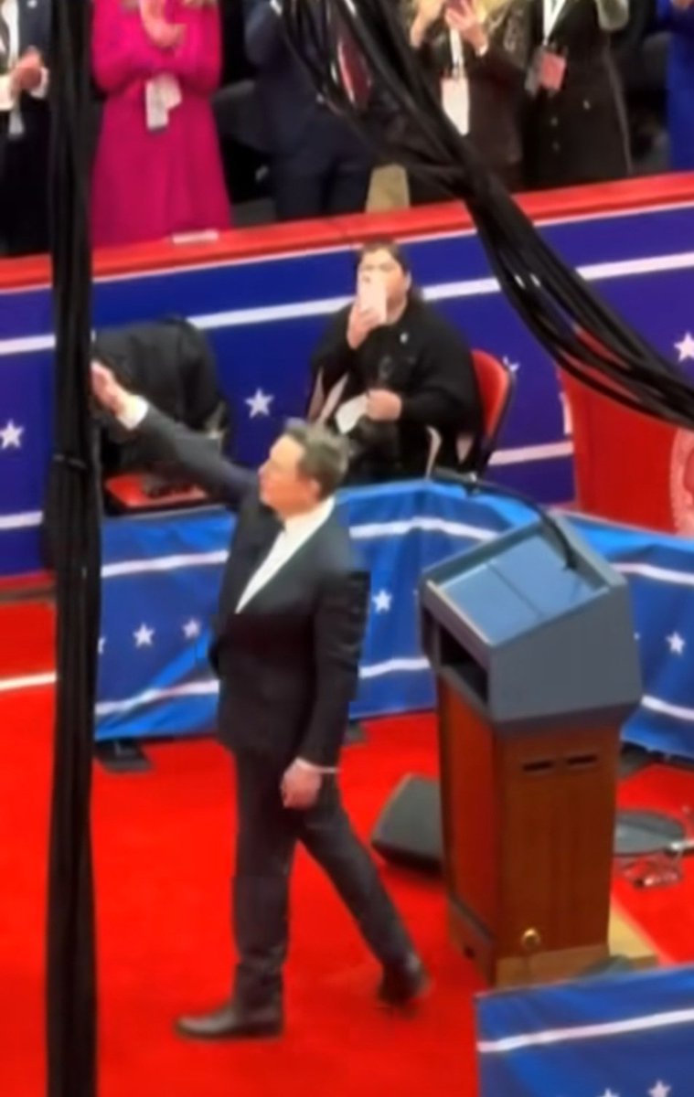 SethAbramson's tweet photo. The first full shot of the _second_ Nazi salute Elon Musk gave from behind the Seal of the President of the United States during the Inauguration has just been revealed. https://t.co/FO5kS35OG5