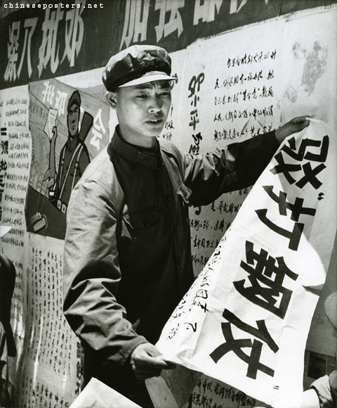 El guardia rojo y soldado Li Yen-ching está colgando su critica titulada "Luchar la Batalla de Acero" en la que critica a Deng Xiaoping por querer cambiar los veredictos de la Revolución Cultural y restaura el capitalismo en China (1976)