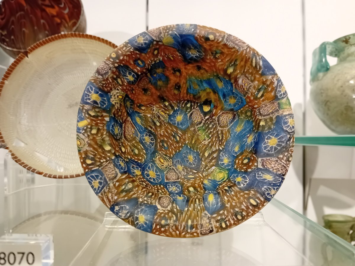 A beautiful small #Roman glass dish, with an irregular pattern of cobalt blue &amp; amber glass interspersed with yellow cane circles (or flowers?) - it was made about 2000 years ago, &amp; is an absolutely gorgeous piece of #AncientGlass! #Archaeology #RomanArchaeology