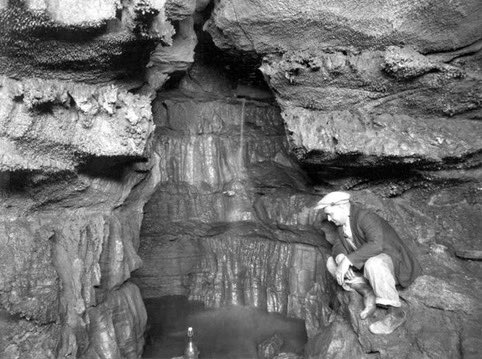 Spelunker Floyd Collins is trapped in Sand Cave, Kentucky when he dislodges a rock that falls and pins his leg. He is trapped 150 feet (46m) from the cave entrance, and a rescue effort begins. 

Floyd’s younger brother Homer, the only person small enough to reach him, is