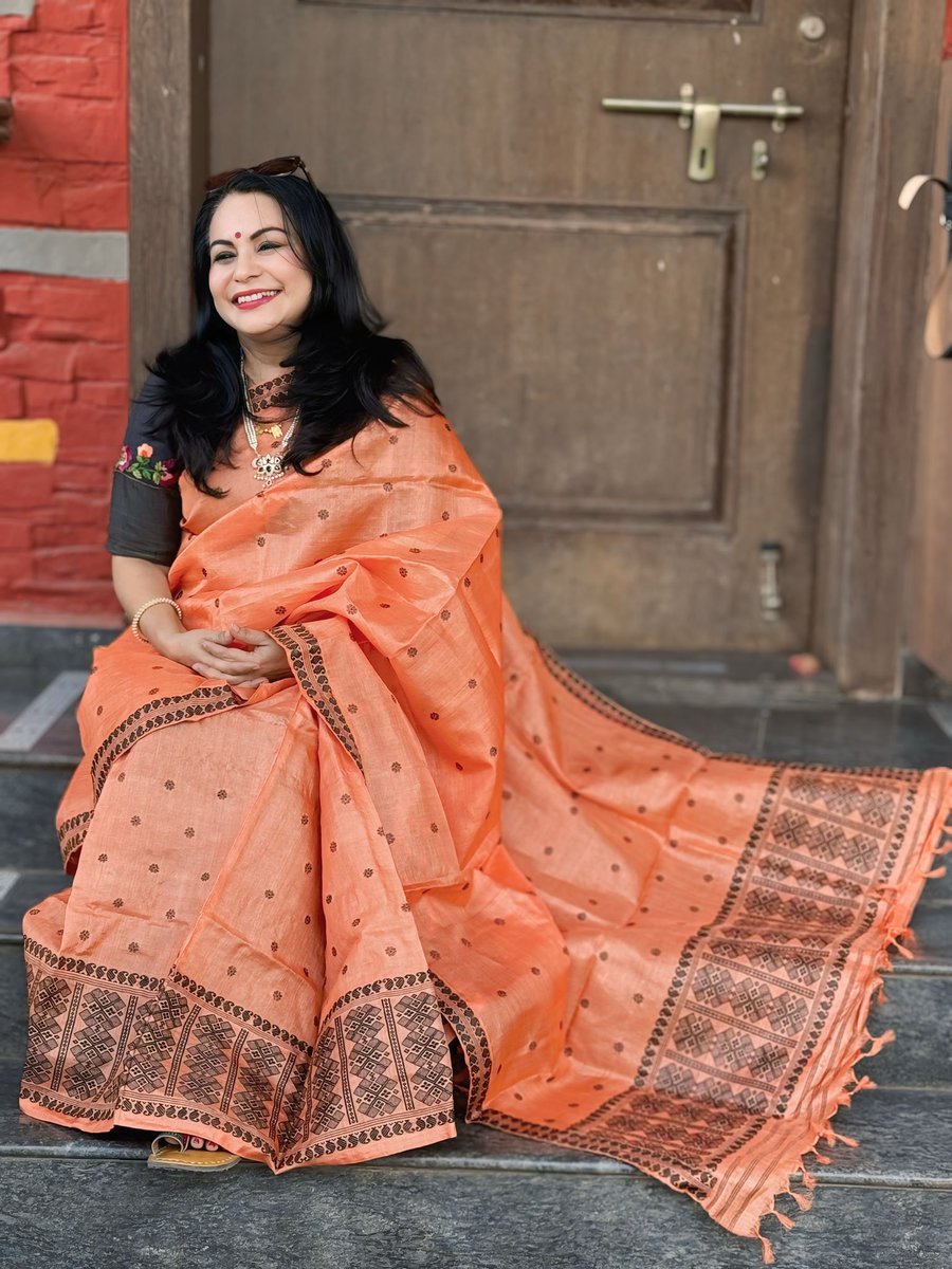 ShefVaidya's tweet photo. #LongRead #SareeSwag #Aboli 

I had draped this saffron-colored Mekhela Sador for one of my events yesterday. In the middle of the mandatory photo session, my usual photographer Suvarna  suddenly exclaimed, ‘Tai, what a beautiful Aboli colour!’ 

The moment I heard the word aboli, my mind was instantly transported straight to my childhood days in Goa. In the Konkan and Goa region, aboli plants bloom in every garden. It was even the state flower of Goa once. 

There is a poetic silence in the very name aboli. It means one who does not speak. But why was this particular radiant orange-saffron flower given the name aboli? After all, aren’t all flowers silent? Yet, this one alone bears the name that signifies quietude. 

Perhaps it is because aboli never blooms with fanfare. It does not have the regal elegance of a rose, the seductive fragrance of ratrani, nor does it dissolve into the morning dew like the delicate parijata. It does not light up the evening with its heady perfume like jasmine or mogara. Aboli simply exists, blooming silently, unnoticed, understated and hesitant, like a shy, introverted girl.

My mother tells me that during her college days, all her friends used to call her Aboli. She truly embodied the name, gentle, soft-spoken, introverted, lost in her own world. Even when someone spoke to her, she would respond with a quiet smile and a few measured words, just like the aboli flower itself. 

But when I look at the English name of this flower, it amuses me. Aboli is called Firecracker flower in English! What a contradiction! In Marathi, the name Aboli signifies silent and demure, whereas in English, the flower is compared to a bursting firecracker! It feels as though this flower bridges the two contrasting temperaments, my mother the quiet Aboli, and me, a perpetually lit firecracker!

Shefali Vaidya