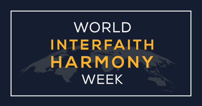 Against a navy-blue background is the silhouette of the world map. Above, is stylized orange and white coloured text reading, ‘World Interfaith Harmony Week’.