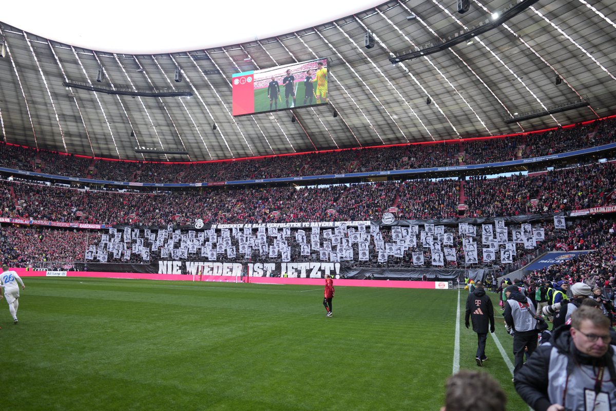 Nie wieder ist jetzt! Vor dem Bundesliga-Heimspiel gegen Holstein Kiel präsentieren die Fans des FC Bayern eine Choreographie zum Holocaust-Gedenktag. Dabei zeigen die Anhänger des Rekordmeisters in der Südkurve Motive von verfolgten FC Bayern-Mitgliedern ab. Umrahmt werden diese