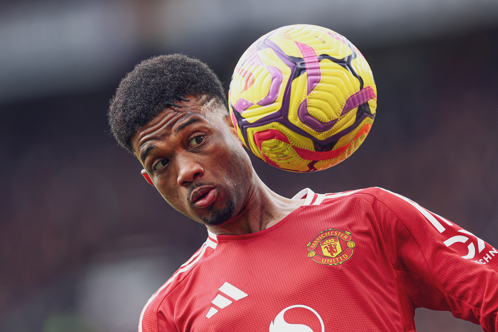 Amad keeps a close eye on the ball as it bounces up near his face.