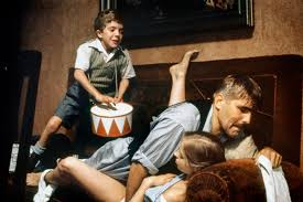 merlinpapin3's tweet photo. .@FredOL69007 #DéfiCinéClassique2025 Février (Anatole Dauman) avec le film #LeTambour de  Volker Schlöndorff(1979) avec David Bennent Mario Adorf Angela Winkler Charles Aznavour Tina Engel Katharina Thalbach Berta Drews Daniel Olbrychski

L'histoire du Tambour est racontée sous la forme d'un long monologue, dont le narrateur n'est autre que le héros lui-même, Oskar Matzerath, un bien étrange personnage qui a incroyablement survécu, avec sa grand-mère protectrice, à la Seconde guerre mondiale. Doté d'une intelligence hors du commun, il reçoit en cadeau, pour son troisième anniversaire, le 12 septembre 1927, un tambour de fer-blanc laqué rouge et blanc. Choqué par le monde des adultes, il décide de cesser de grandir. Pour cela, il fait exprès de tomber du haut des escaliers de la cave de sa maison et va ainsi conserver sur le monde un regard d'enfant implacable et inflexible. Il découvre qu'il a le talent particulier de pousser un cri strident de haute fréquence qui casse le verre alentour.

Volker Schlöndorff signe avec Le Tambour (Die Blechtrommel), adapté du roman éponyme de Günter Grass, une œuvre fascinante et dérangeante, où l’enfance se mue en résistance face à un monde en décomposition. Coécrit avec Jean-Claude Carrière, le scénario suit le parcours d’Oskar Matzerath, un enfant qui, par un acte de refus absolu, décide à trois ans de ne plus grandir après une chute sur la tête. Son instrument fétiche, un petit tambour rouge et blanc, devient son unique langage, une arme contre la médiocrité et la brutalité des adultes.

David Bennent, âgé de 11 ans au moment du tournage, livre une performance inoubliable, incarnant ce personnage à la fois enfantin et inquiétant. Son regard perçant, sa maturité troublante et son cri strident – capable de briser le verre – donnent à Oskar une dimension quasi mythologique. Il traverse l’histoire de l’Allemagne des années 1920 aux lendemains de la Seconde Guerre mondiale avec une lucidité qui le distingue de son entourage aveuglé par l’idéologie.

Le film ne recule devant rien pour illustrer la montée du nazisme et la compromission générale. La scène où Oskar interrompt un rassemblement hitlérien en détournant une marche militaire vers une valse grotesque est l’un des moments les plus marquants du film : son tambour devient une force subversive, un instrument de révolte contre l’ordre établi. Mais cette rébellion ne suffit pas à arrêter la marche inexorable du chaos.

Un des aspects les plus controversés du film reste la relation entre Oskar et Maria, une jeune femme plus âgée. Cette scène, jugée choquante par certains, interroge les frontières de l’enfance et de la sexualité dans un corps resté figé à trois ans. Oskar, malgré son apparence, est un être hybride, un esprit adolescent dans un corps d’enfant, ce qui rend ces moments profondément troublants.

Visuellement, Schlöndorff restitue avec brio l’atmosphère du Dantzig d’avant-guerre, ville cosmopolite où se croisent Allemands, Polonais et Cachoubes. L’omniprésence du tambour d’Oskar rythme le film comme une litanie funèbre, battant la mesure d’un monde qui court à sa perte.

La Palme d’Or obtenue en 1979, partagée avec Apocalypse Now, souligne la puissance du film : deux visions de la guerre, l’une hallucinée et infernale chez Coppola, l’autre cruelle et grotesque chez Schlöndorff. L’Oscar du Meilleur Film Étranger en 1980 viendra consacrer ce chef-d’œuvre du cinéma allemand.

David Bennent, après ce rôle emblématique, n’a jamais connu une carrière aussi marquante, bien qu’il ait continué à tourner au cinéma et au théâtre. Mais son visage, figé dans le temps, hante toujours ceux qui ont croisé son regard sur grand écran. Le Tambour reste une fable tragique sur l’impossible innocence et la déliquescence d’une époque, un film dont on ne sort pas indemne.