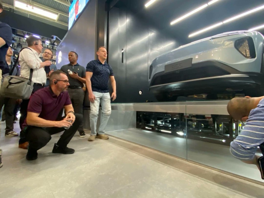 去年北京车展，一群老外围着蔚来换电站研究的照片，被很多人转发了。

当年中国汽车工业不发达，我们的工程师只能以学徒姿态，望着外资品牌感慨。

如今，老外们蹲下去，中国品牌站起来。