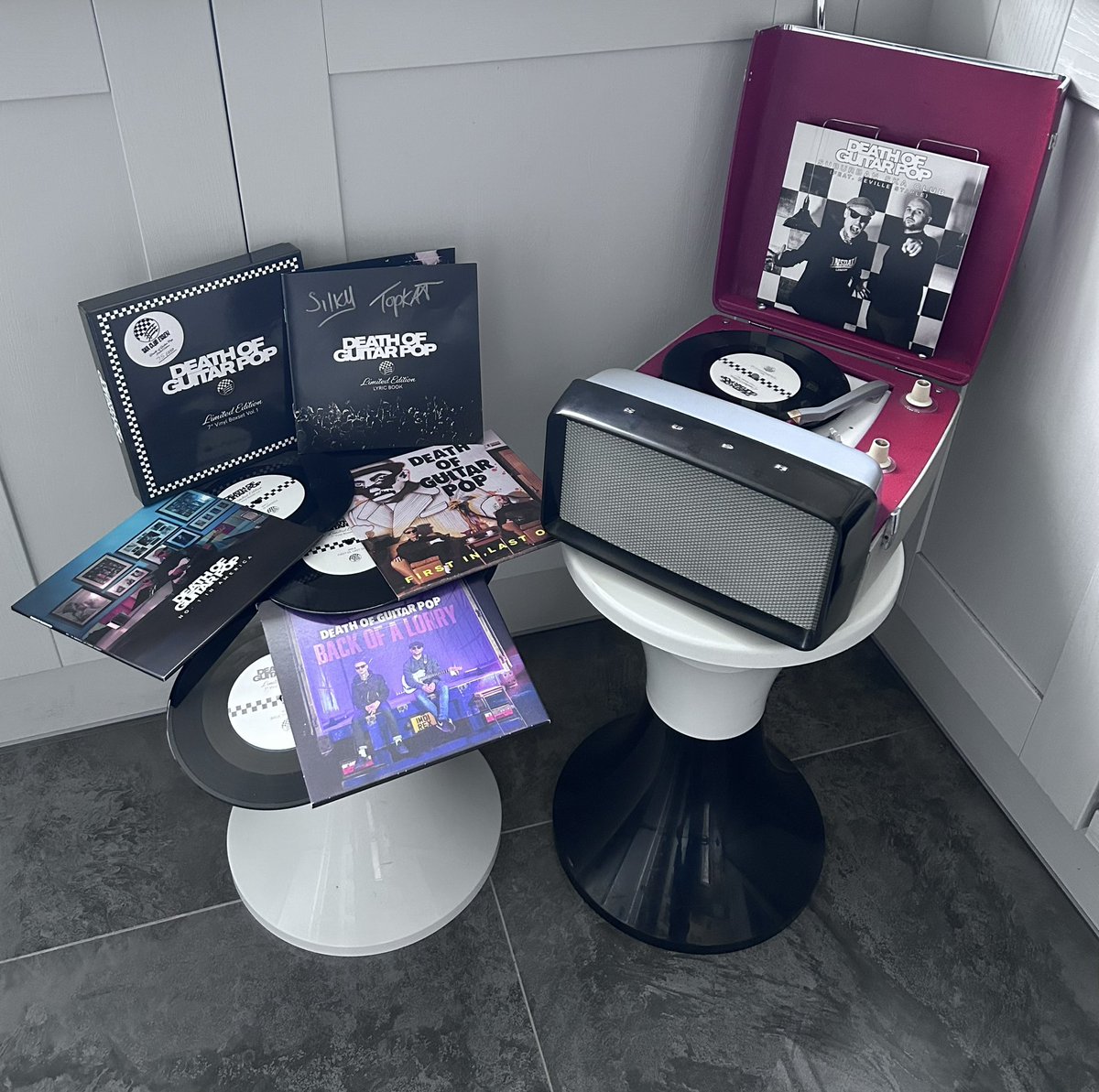 benchampniss's tweet photo. Enjoying this very limited edition (75/250)  Death of Guitar Pop 7” boxset, this morning!! Signed by the band! Sounding great on my Bush Top Ten battery operated portable 45 player and radio, from 1960! Can anyone spot the funny looking bloke in the hat on the lyric page for Back of a Lorry…? 

@dogpska  #deathofguitarpop #silky #topkat #ska #nowplaying #nowspinning #vintageturntable #vinyl #bushtoptenplayer #bushtopten