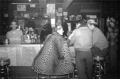 ANC_Historian's tweet image. Mid 1950s, Eadie Henderson (1926-2000) at Kenai Joe's bar. In 1952, the former stripper opened the Last Frontier, a strip club/brothel. She ran it for decades, fending off several attempts to close it with significant support from its KPen regulars. #alaskahistory #alaska