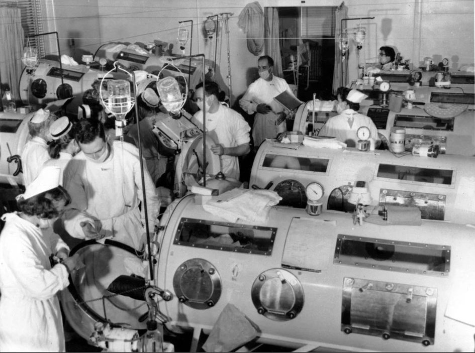 An unfamiliar scene, medical professionals using "iron lungs" help people (most of them children) breathe after having their diaphragms permanently paralyzed by Polio. 

This is what life was like before vaccines. Mother nature will kill you the first chance she gets...