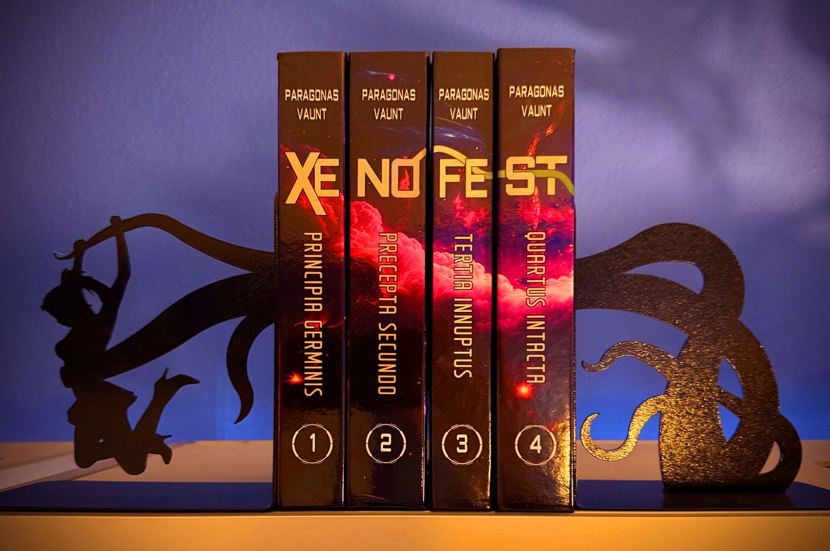 ParagonasVaunt's tweet photo. Wow! A dedicated reader has kindly sent me this picture of their print copies of Xenofestation, on their bookshelf out there in the wild. Check 'em out! https://t.co/tupv2o7IJC