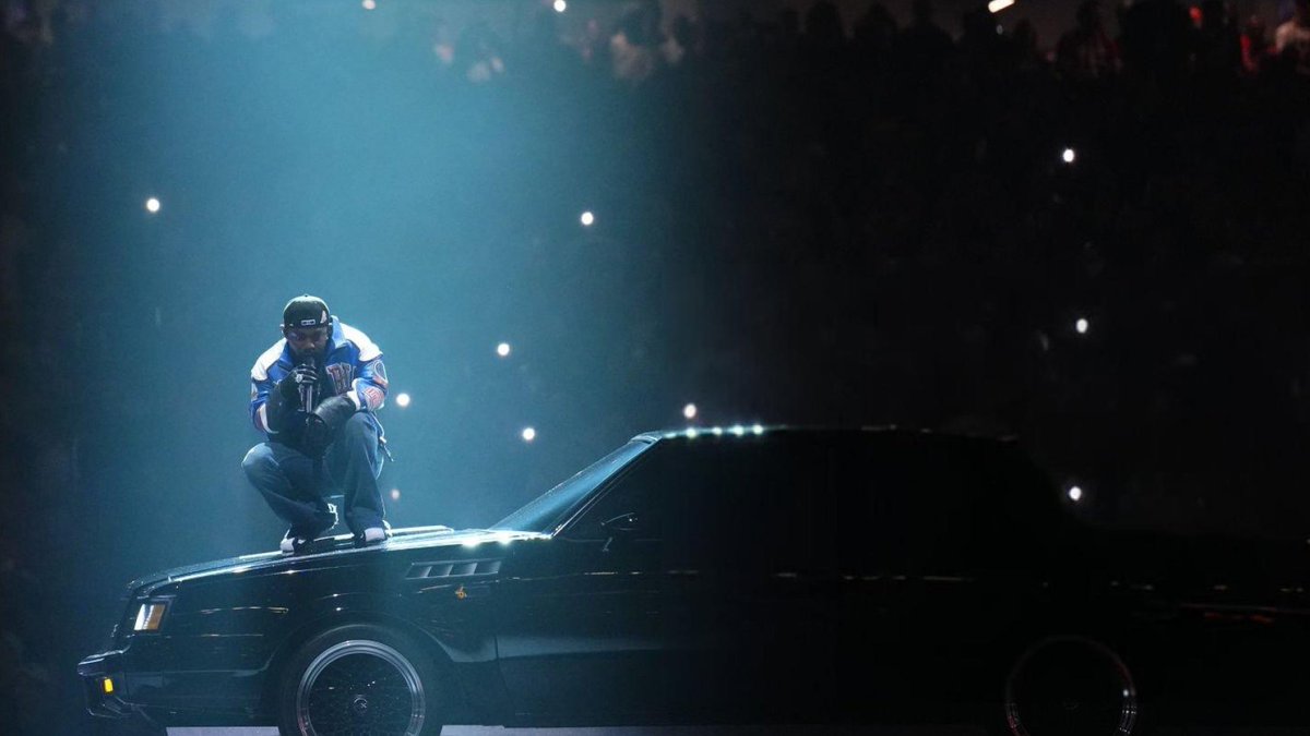 Kurrco's tweet photo. A protestor with a Sudan / Palestine flag made his way onto the stage during Kendrick Lamar's #SuperBowl Halftime Show https://t.co/rNJ6Pd9k6D