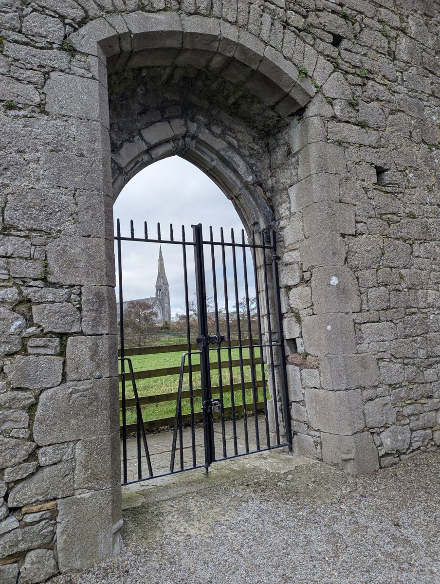 Jim73131158's tweet image. Steeple of Saints Peter and Paul in the distance, through a not so aesthetically pleasing metal gate in the Dominican Priory of Kilmallock, County Limerick

 #lovesgates #thursgate #ireland #Archaeohistories #Archaeology
