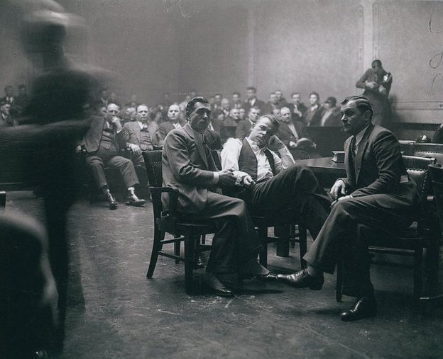 LiterateIndy's tweet photo. John Dillinger (shirtsleeves) handcuffed to Deputy Sheriff R. M. Pierce in a courtroom in Crown Point, Indiana, February 1934.

Dillinger escaped a few weeks later.
(Indiana Album, Joan Hostetler Collection) https://t.co/hwM47wrqvH