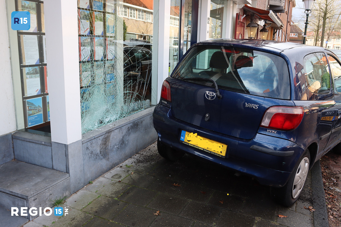 Automobilist ramt gevel van makelaardij
