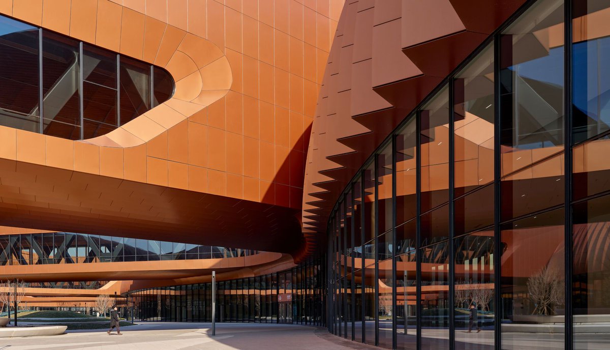 Archello's tweet image. Zaha Hadid Architects' (@ZHA_News) CIECC in Beijing features a modular composite roof for vast column-free spaces and a pleated, deep copper-hued façade balancing scale and materiality.
buff.ly/41kP1G5
#ModularArchitecture #SustainableDesign #LargeSpanStructure
