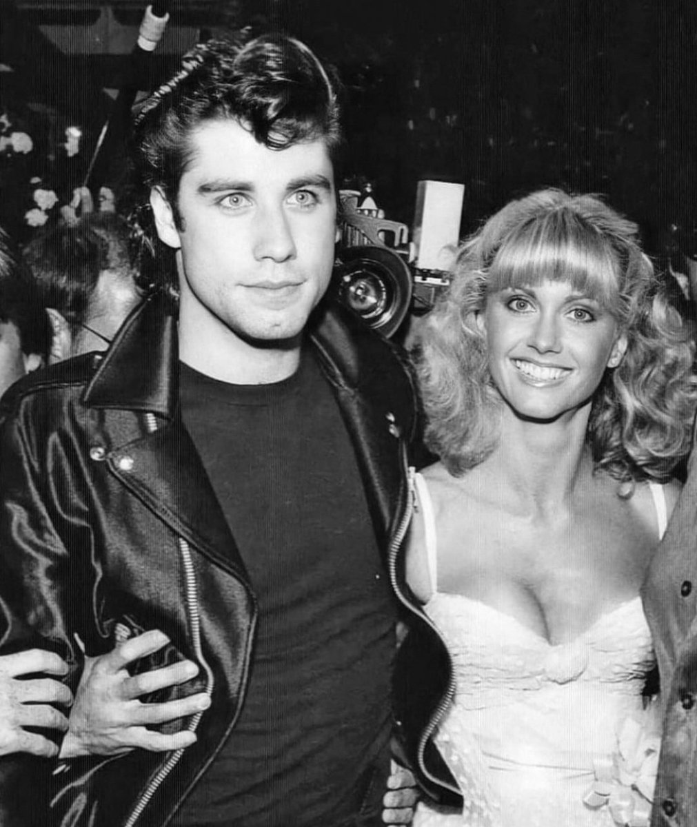 JuanmadelaPoza's tweet photo. Recordando que #JohnTravolta cumple 71 años con esta estupenda fotografía en la que aparece junto a #OliviaNewtonJohn en el estreno mundial de #Grease (1978), de #RandalKleiser. Una deliciosa e inolvidable película basada en el musical homónimo de 1972 creado por #JimJacobs y #WarrenCasey. Un filme que ha marcado a más de una generación de espectadores. Os reconozco que no me veo capacitado para escribir en un solo tuit lo genial que me parece «Grease». Para mí hablar de «Grease» no es hablar de una película. Es hablar de todo un conjunto de emociones maravillosas, recuerdos magníficos y sentimientos inolvidables. Cada vez que vuelvo a ver «Grease» me sigue emocionando como la primera vez. Como sucede con tantas películas míticas, «Grease» se mantiene en mi memoria gracias a una mezcla de esa nostalgia cinéfila que todo lo maquilla y al cariño que siento por ese tipo de películas que, sin ser obras maestras, son lo suficientemente sólidas a un nivel narrativo (pese a lo básico de su puesta en escena) y nunca se toman en serio a sí mismas. John Travolta saltó a la fama con #FiebreDelSábadoNoche (#SaturdayNightFever), de #JohnBadham, en 1977. Un año más tarde volvió a triunfar en la gran pantalla con «Grease». En «Grease» John Travolta interpreta a Danny Zuko, un rebelde estudiante de secundaria que durante el verano conoce a la ingenua rubia australiana Sandy Olson (Olivia Newton-John). Creyendo que nunca más se volverán a ver, Danny y Sandy coinciden en la misma escuela secundaria. Sin embargo, en su afán de no perder su fama de rudo, Danny hace todo lo que puede por evitarla, iniciando con la chica una especie de guerra fría en la que participirán los amigos de ambos. Tras el éxito espectacular de «Fiebre del sábado noche», el productor australiano #RobertStigwood (#JesusChristSuperStar, 1973) concentró todos sus esfuerzos en contratar a John Travolta para su próximo proyecto cinematográfico, después de que este apareciera en la versión teatral de «Grease» (1971), de Jim Jacobs y Warren Casey, que venía representándose en el Broadhurst Theatre de #Broadway. John Travolta tenía una carrera incipiente como cantante con éxitos como «Let Her In» (1976) y había ganado mucha notoriedad como actor y bailarín interpretando a Tony Manero, por lo que estuvo en posición de sugerir al productor el nombre de Randal Kleise, con quien había trabajado en #ElChicoDeLaBurbujaDePlástico (#TheBoyInThePlasticBubble, 1976) como director y a Olivia Newton-John, conocida en aquel momento casi exclusivamente como una cantante de pop y country ganadora de varios Grammy, como la coprotagonista femenina. Por su parte, Olivia Newton-John solo tenía dos créditos fílmicos antes de unirse al proyecto de «Grease», las prescindibles #FunnyThingsHappenDownUnder (1965), de #JoeMcCormick, y #Toomorrow (1970), de #ValGuest, una comedia australiana y un musical británico, respectivamente. La actriz y cantante solo aceptó el papel después de una prueba musical para evitar otro revés en su carrera. A pesar de que el productor #AllanCarr tuvo en mente a otras actrices para el papel de Sandy como #AnnMargret, #SusanDey y #MarieOsmond y que Olivia Newton-John no podía sacarse de encima su acento australiano –la cantante había vivido gran parte de su vida en Australia- finalmente se quedó con el papel gracias a su calidad vocal y apariencia de niña buena, que le venía como anillo al dedo para interpretar a la inocente Sandy Olson. Curiosamente, tras el éxito de «Grease», la intérprete experimentó una transformación muy similar a la de su personaje en el filme. De una ingenua y risueña adolescente a una atractiva y atrevida mujer, lo que se reflejó en su siguiente álbum «Totally Hot» (1978). Son muchas las claves que hacen de «Grease» una película icónica y muy recordada actualmente. Me quedo con el romance de Danny y Sandy, la lucha de sexos en la escuela secundaria y su estructura musical (la mayoría de las canciones son extraordinarias).