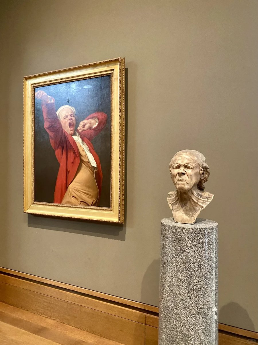 In this compelling museum display, a dramatic painting and a detailed sculpture come together, capturing the intensity and emotion of the subject from two distinct perspectives.