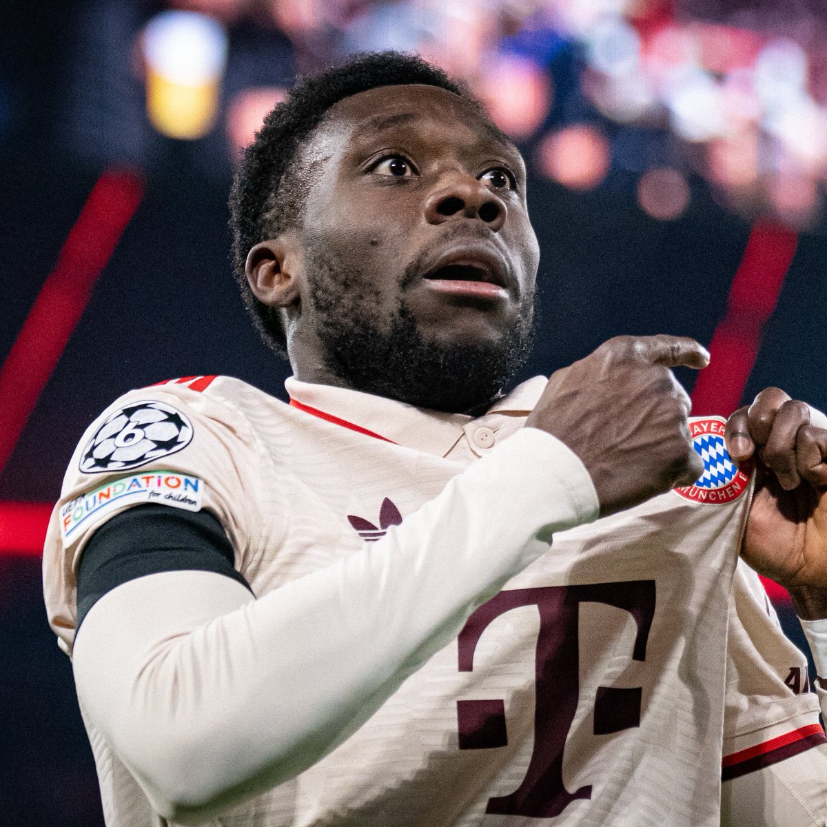 Alphonso Davies kisses and points to the badge after his goal