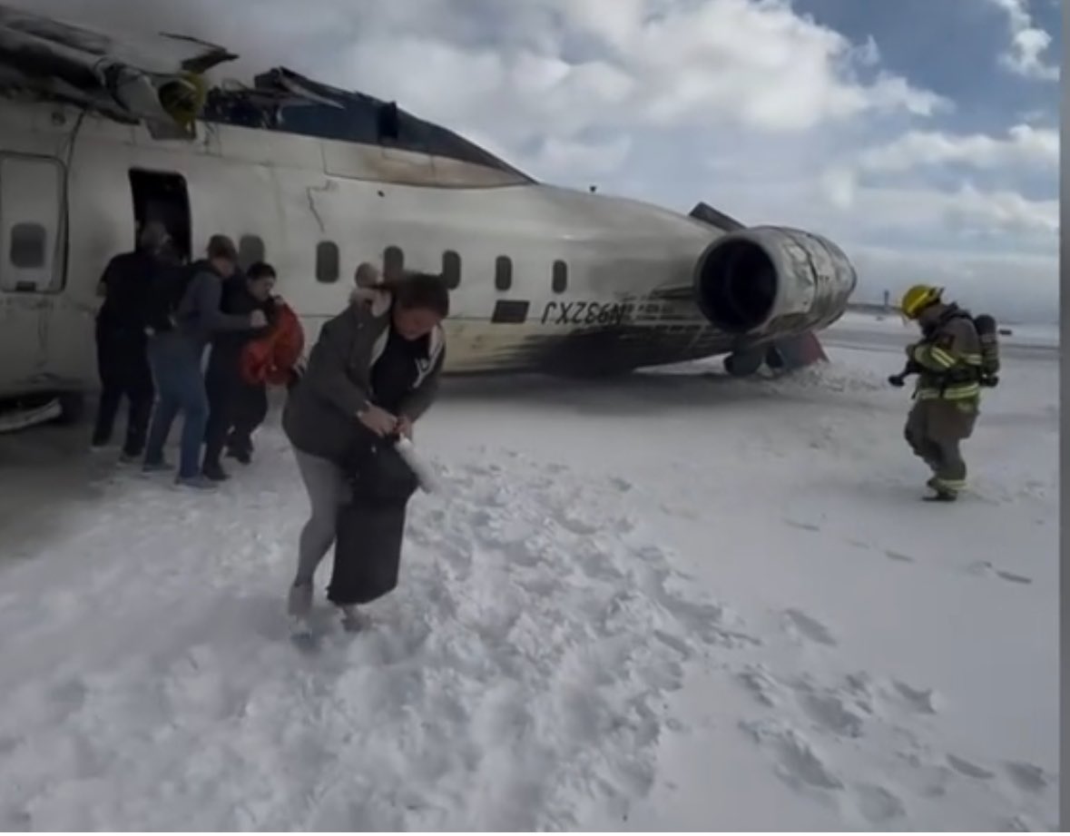 Toronto crash: Hats off to her, plane flipped upside down but this lady still got off the with her massive bag. Do you think she calmly got it out of the overhead locker?