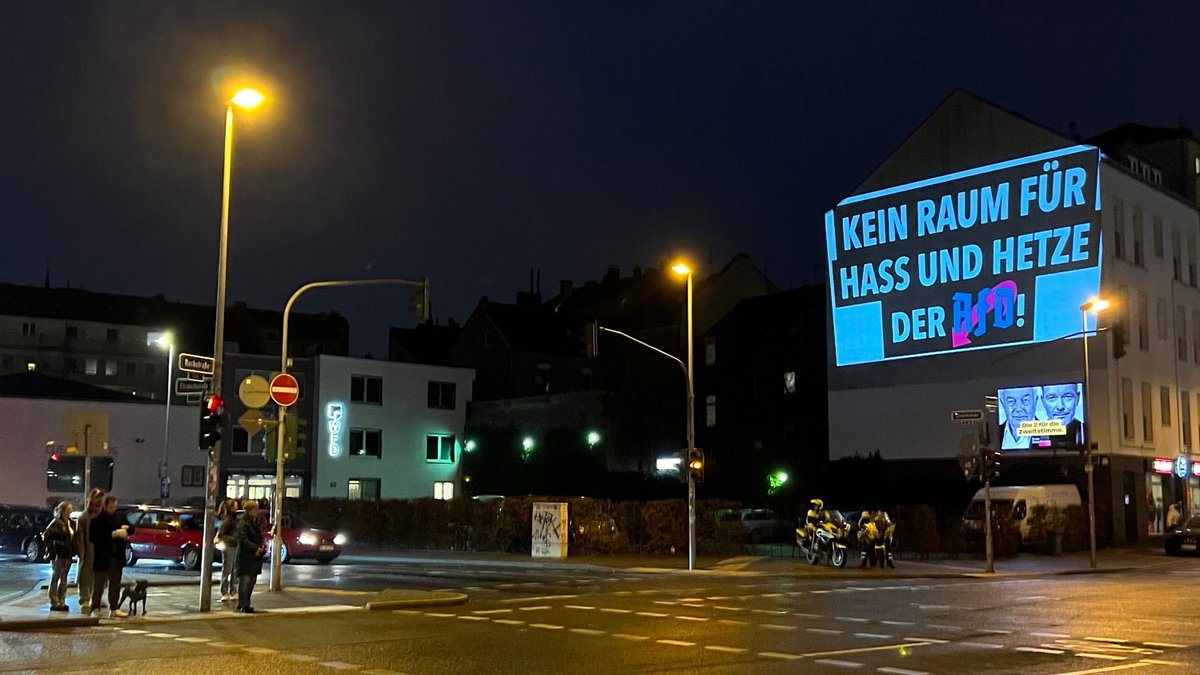 InfoportalDUS's tweet photo. Mehrere hundert Menschen protestieren vor dem „Bürgerhaus Bilk“ gegen eine Veranstaltung der AfD.
An einer Häuserwand sind verschiedene Lichtprojektionen zu sehen deren Inhalte sich gegen die extrem rechte Partei richten.
#NoAfdDus #dus2002 https://t.co/nixg2Dujur
