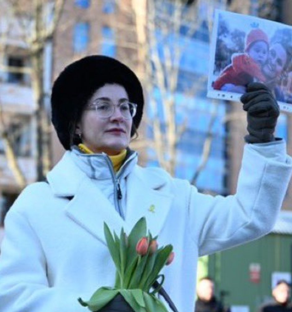 OliLondonTV's tweet photo. This is what a hero looks like. 

Every week since the October 7th attack, a lone German woman has silently stood in front of pro-Hamas protesters. 

Week after week, @PreislerKa has stood in front of the baying mobs as they taunt her and chant Hamas slogans. 

Yet despite this, she stands with her head held high with dignity. 

 She does not engage with them. 

She does not speak. 

She simply holds photos of October 7th victims and photos of hostages. 

She holds a bunch of flowers. 

Flowers to commemorate the women whose lives were so cruelly taken.  

This is what a hero looks like.