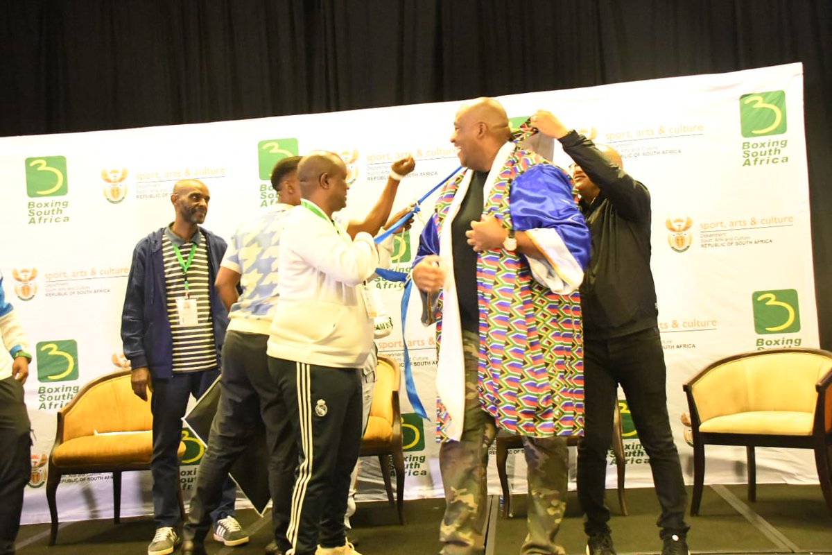 SportArtsCultur's tweet photo. DAY 2 | National Boxing Convention at East London ICC

Chairperson of the @BoxingSA_boxing  together with the BSA Manco handing tokens of appreciation to Minister McKenzie and Acting Director-General Dr Khumalo

Flaunting their BOXING gowns... they are War Ready! 🥊🥊

#NationalBoxingConvention 
#InspiringANationOfWinners
#SASports 
#BoxingSA