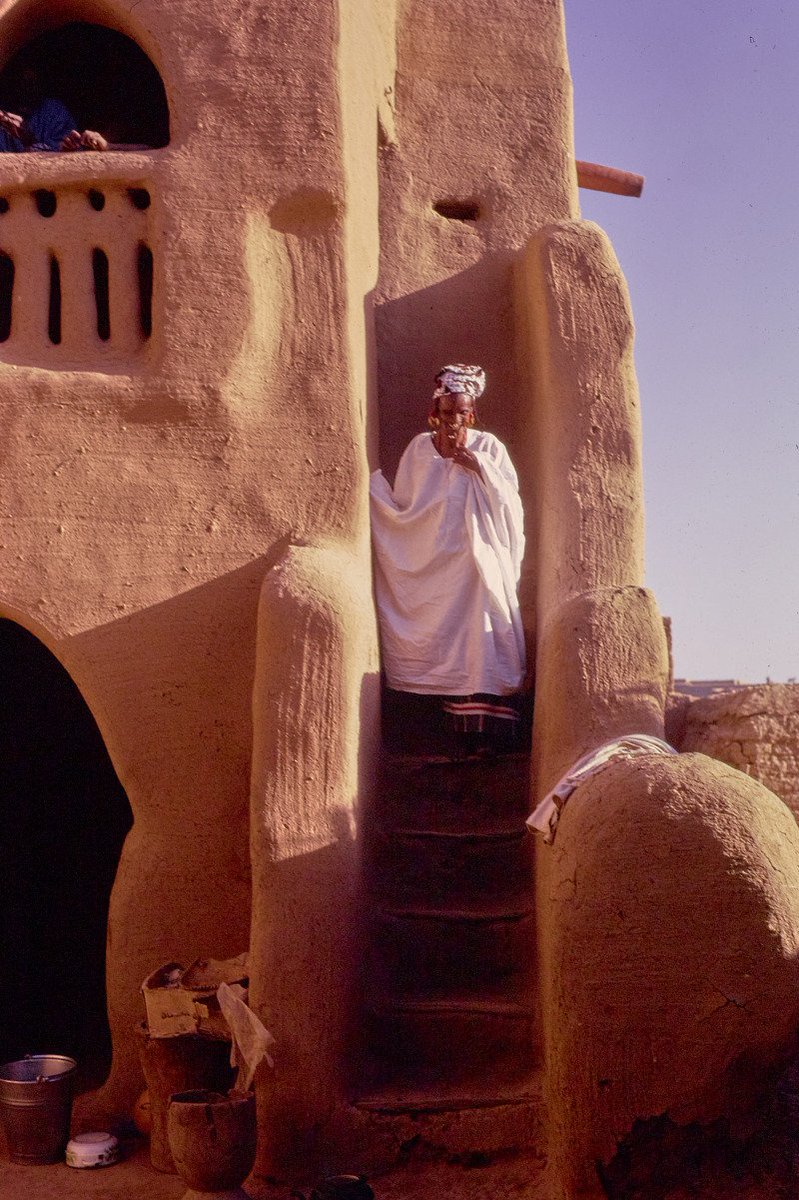 Photographie d'une femme sur les escaliers d'une maison à Djenné, dans la deuxième moitié du 20e siècle.