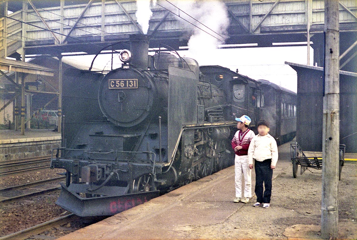 飯山線  222レ
1971年11月   豊野
飯山始発のこの列車は豊野で２両増結し、通勤・通学客満載の客車７両を引いて長野へ向かう。
機関車からは発車前の気合いが伝わってくるようだ。時に鉄道青年8歳、父親の撮影。
#飯山線