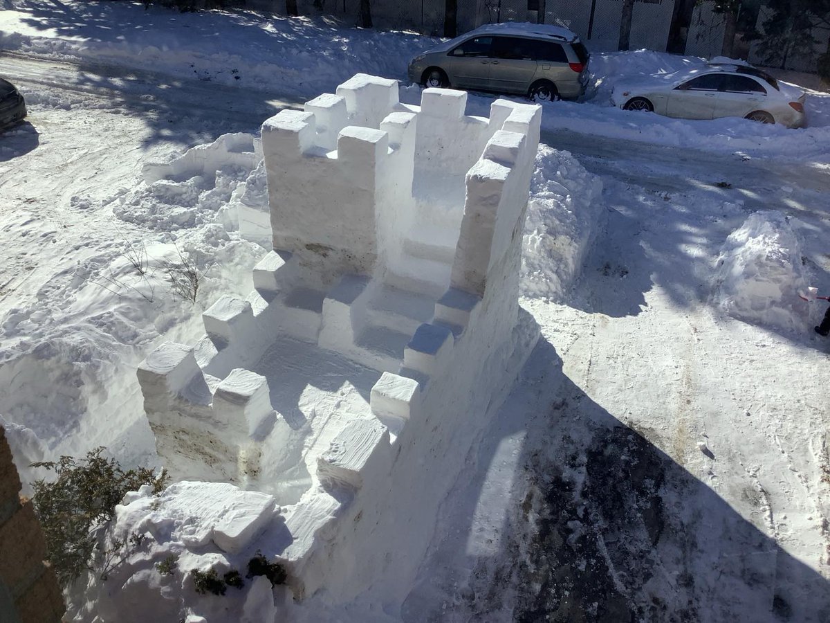This morning I finished the snow fort in front of my house. I mainly worked on the finishing touch by smoothing the walls and arranging the battlements.