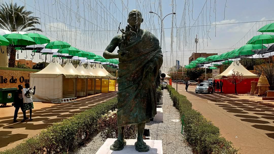 Faso7_BF's tweet photo. 🎬#FESPACO2025 : La statue du cinéaste ivoirien Roger Gnoan M'Bala trône à #Ouagadougou.  Étalon d'or au FESPACO en 1993, sa statue a rejoint celles des illustres réalisateurs africains comme Idrissa Ouédraogo et Sambène Ousmane, sur la rue des cinéastes, à Ouagadougou. https://t.co/kH9AzkE45m