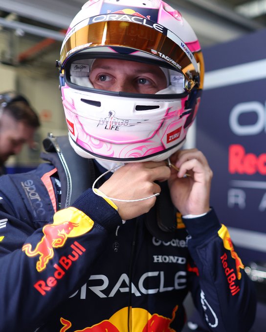 Liam Lawson tightens his helmet strap in his Oracle Red Bull Racing driver suit, in the garage at Jerez.