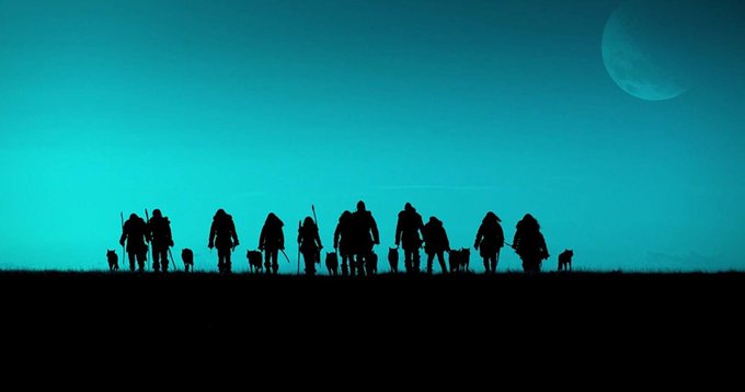 A group of people with wolves walking together on grassy land and the moon behind them. The color of the sky is close to cyan.