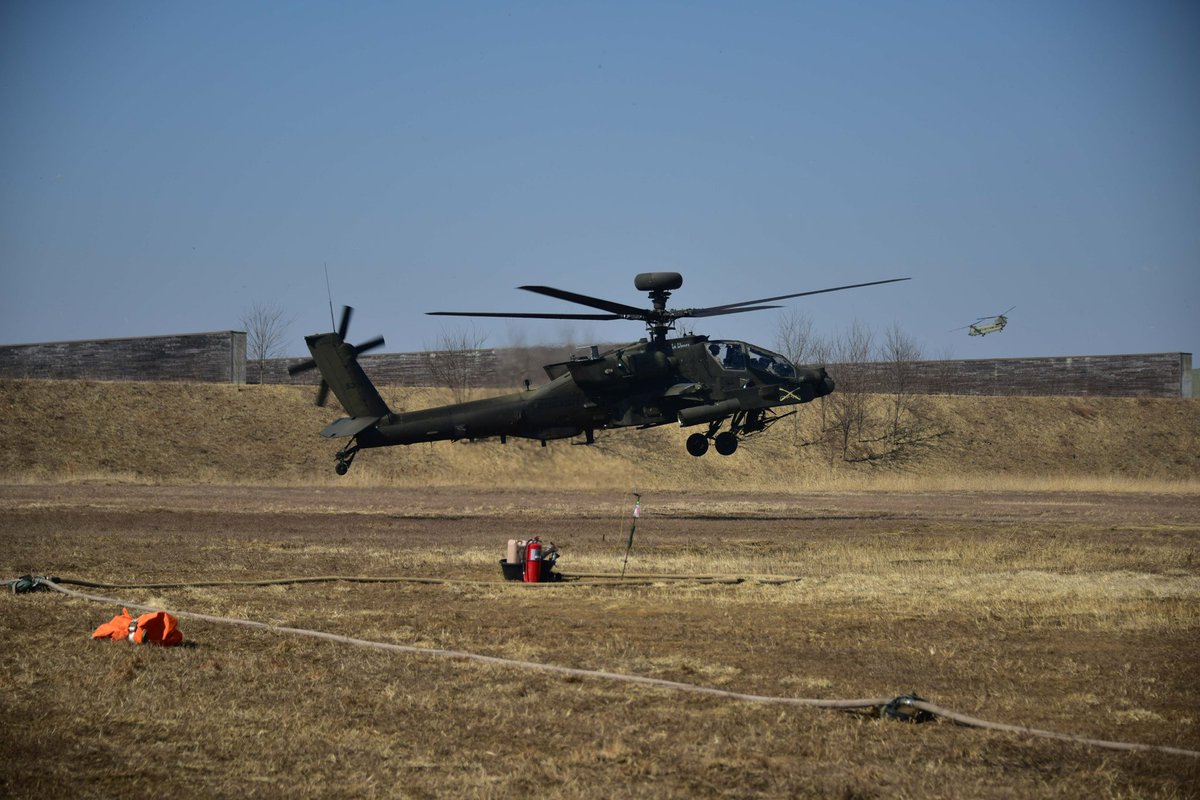 2INFDIV's tweet image. Soldiers from the 5th Squadron, 17th Cavalry Regiment, 2nd Combat Aviation Brigade, perform field maintenance on an AH-64 Apache at the Forward Arming and Refueling Point (FARP). The maintenance ensures the aircraft remains mission-ready.