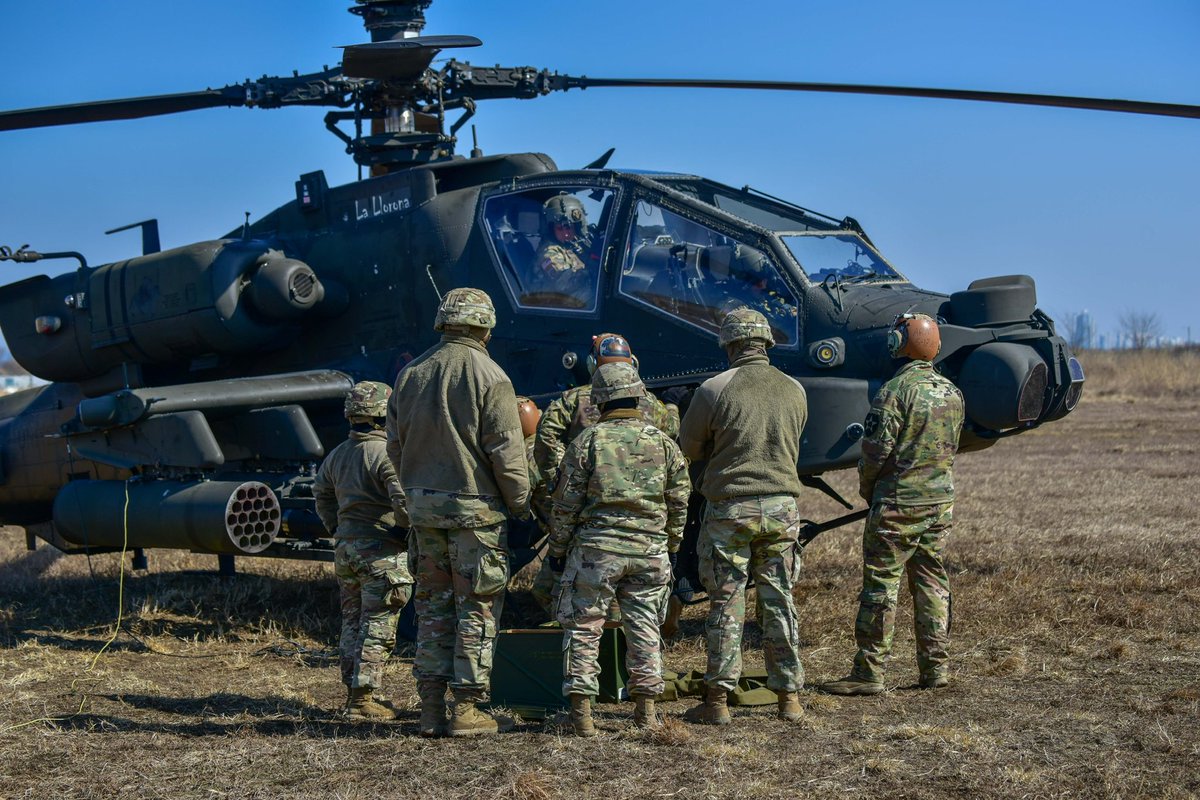 2INFDIV's tweet image. Soldiers from the 5th Squadron, 17th Cavalry Regiment, 2nd Combat Aviation Brigade, perform field maintenance on an AH-64 Apache at the Forward Arming and Refueling Point (FARP). The maintenance ensures the aircraft remains mission-ready.