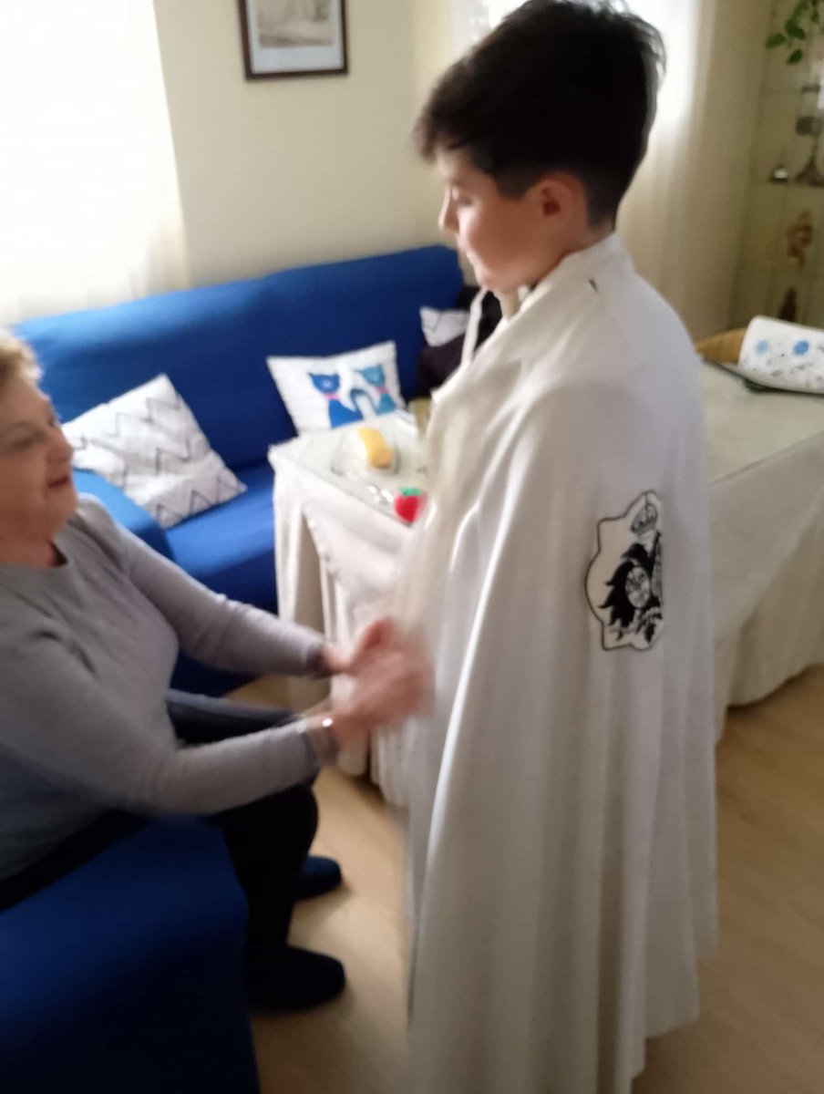 Tradiciones que no se deben perder. La abuela probando a su nieto la túnica de sus hermandades, <a href="/HermandadSJO/">Hermandad de San José Obrero</a> y <a href="/HdadCachorro/">El Cachorro</a>