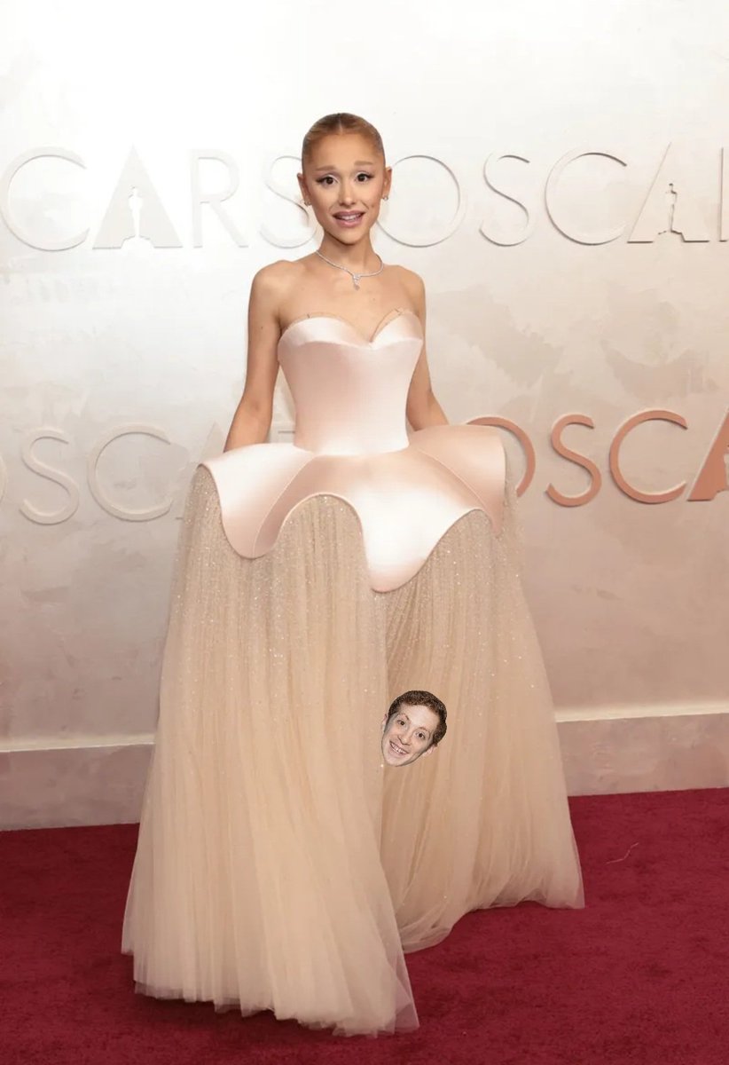 Ariana Grande stuns on the #Oscars red carpet while a shy Ethan Slater peeks his head out to check for any birds of pray who might swoop down and carry him off.