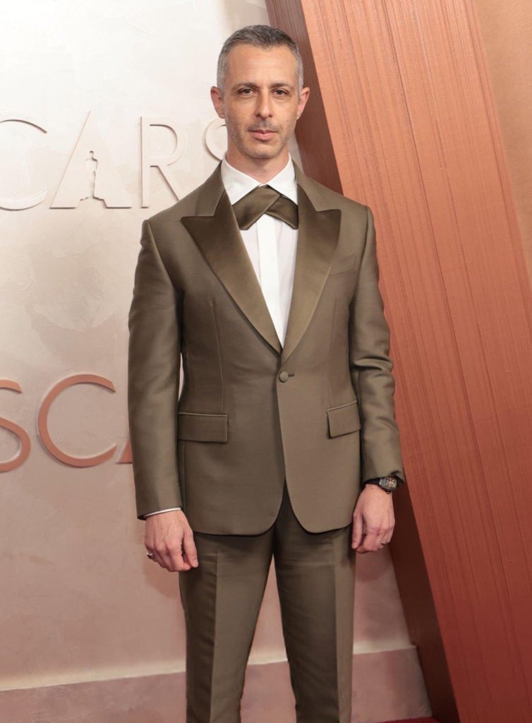 Jeremy Strong watching Oscar Nominees enter the Academy Awards from outside in 1993 // Jeremy Strong entering the Academy Awards as an Oscar Nominee in 2025